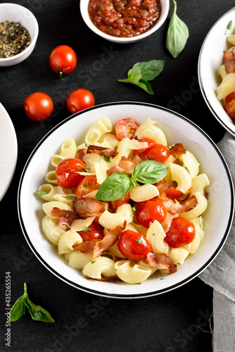 Pasta with bacon, tomato, parmesan cheese and basil leaves