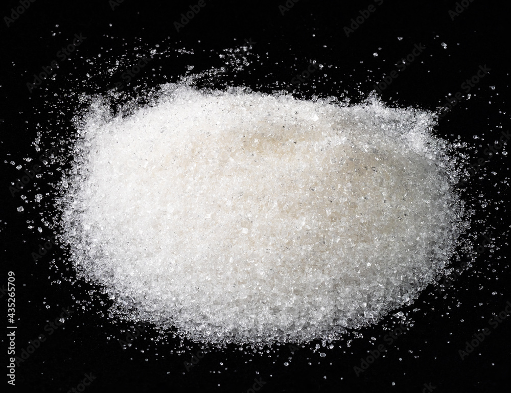 handful of white sugar from sugar beet on black handful of white sugar from sugar beet on black