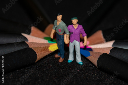 Homosexual men miniatures with wooden colorfull pencils photo