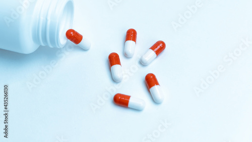 capsules with medicine and a bottle on a white background.