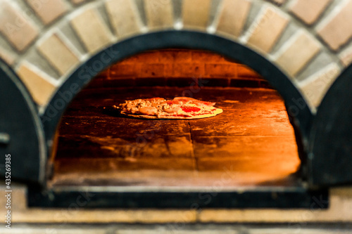 Pizzaiolo Preparing Artisan Pizza Cooking in Oven Heat Fire