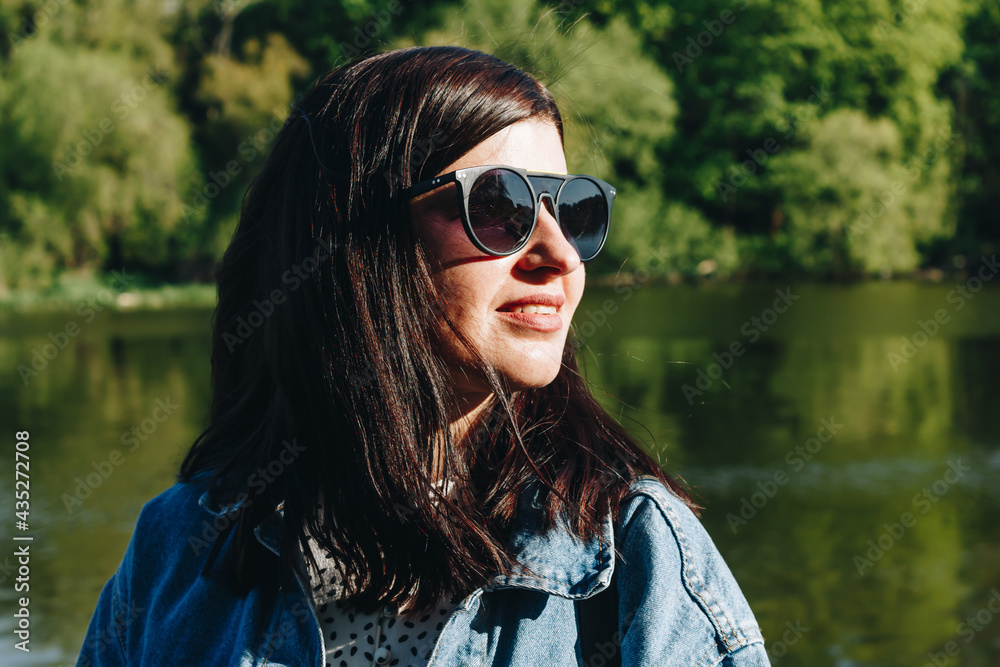 Portrait of brunette woman in sunglasses and jean jacket Portrait of brunette woman in sunglasses and jean jacket