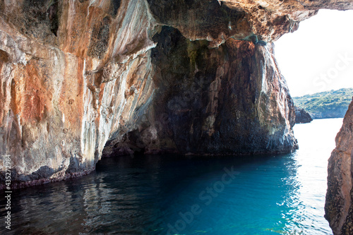 Enthralling sea cave in the calcareous cliff outcropping on an aquamarine sea along Marina di Camerota seaboard, Italy, Europe.