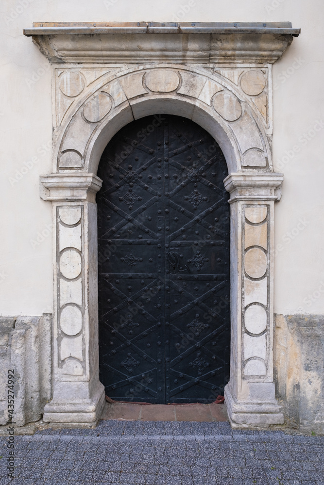 Old steel door with decorative stone portal