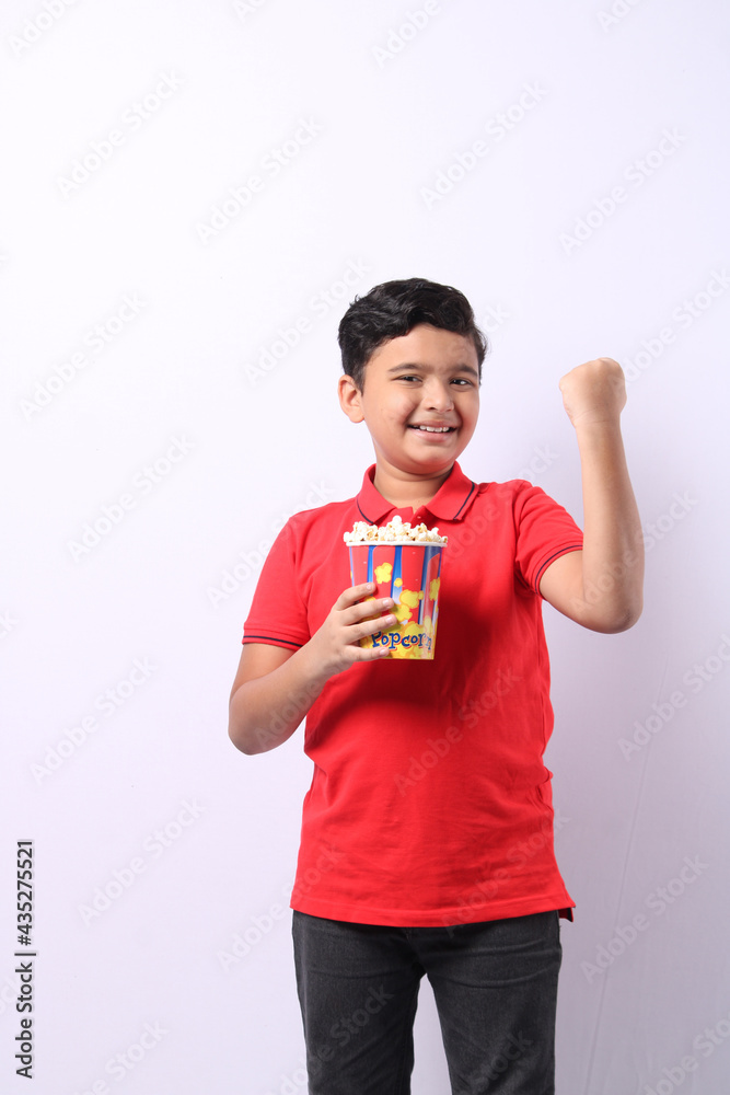 happy little Indian boy eating popcorn happy little Indian boy eating popcorn