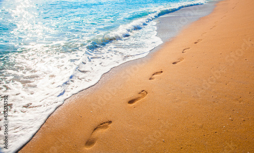 Fototapeta Naklejka Na Ścianę i Meble -  footprints on  tropical beach and beautiful  wave