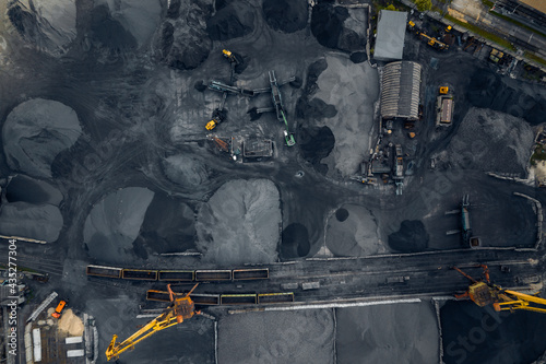 Loading and unloading coal on ship terminal sea cargo port, industrial background, aerial top view