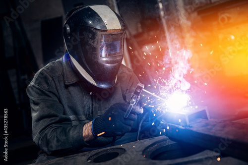Welder work with metal parts car in factory, sparks and electricity