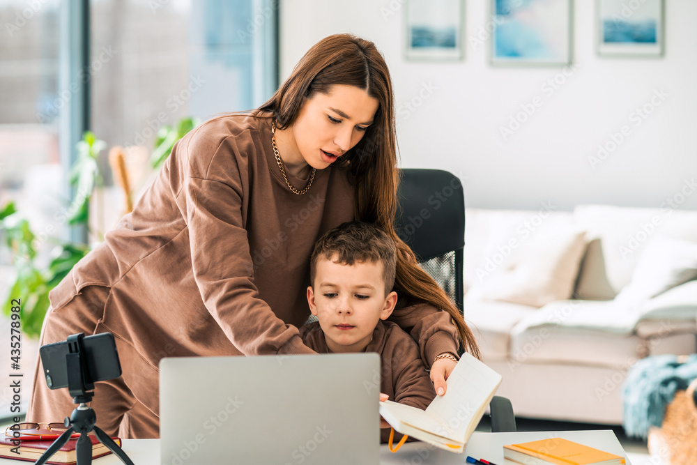 Mother helps her son with online distance education Mother helps her son with online distance education