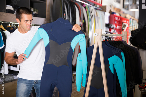 Young male chooses sportswear in a clothes store