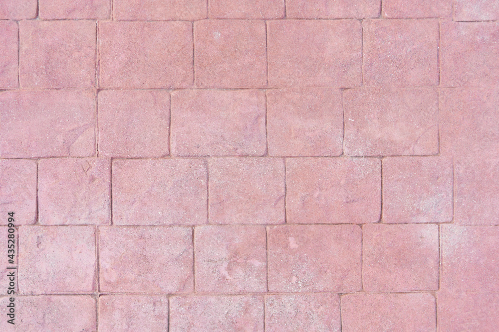 Fototapeta premium Front view of a wall of irregular shape tiles or slabs. Reddish textured background