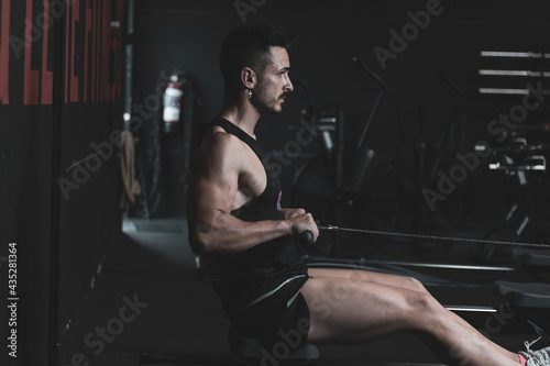  young man training inside a gym with functional exercise. athlete body