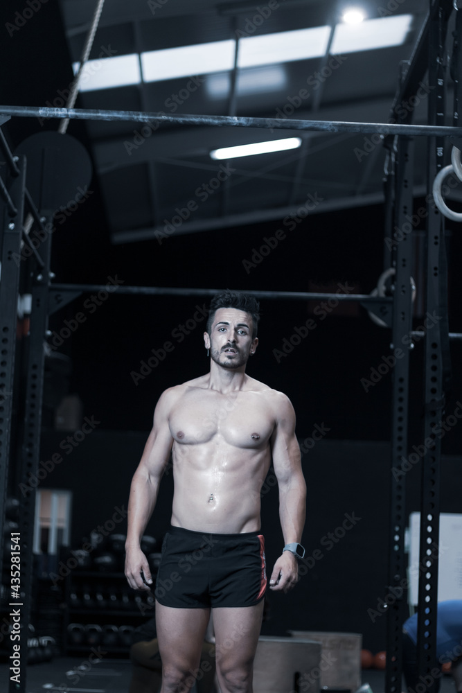 Naklejka premium young man training inside a gym with functional exercise. athlete body