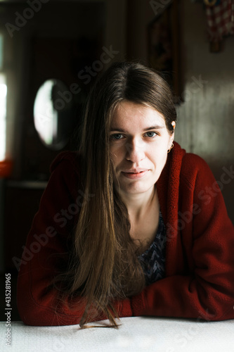 Portrait of young woman sitting at the table in the her house.