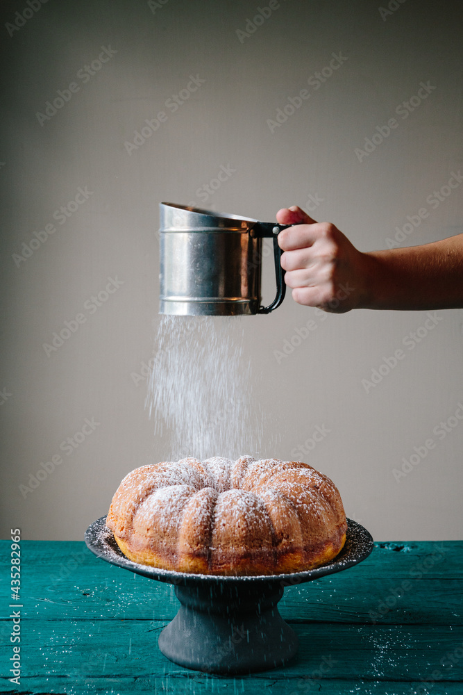 Sifting powdered sugar on bundt cake Stock Photo Adobe Stock
