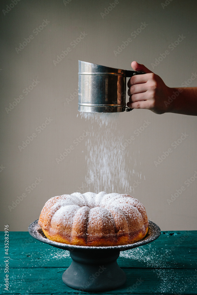 Sifting powdered sugar on bundt cake Stock Photo Adobe Stock