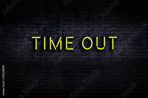 Photos Neon sign. Word time out against brick wall. Night view
