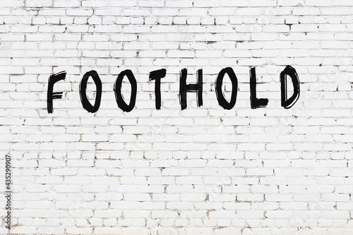 Inscription foothold painted on white brick wall