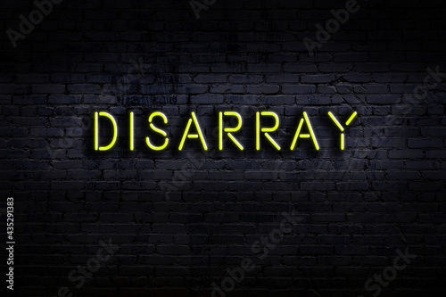 Night view of neon sign on brick wall with inscription disarray photo