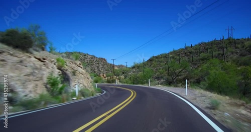 Driving on a curvy winding Apache Trail Arizona desert scenic road on way to Canyon Lake pulling over allowing 3 vehicles to pass. photo