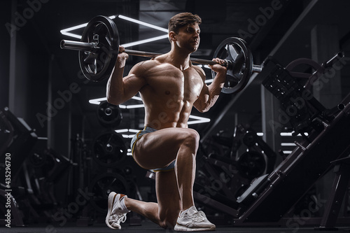 athletic man pumping doing lunges exercises in gym