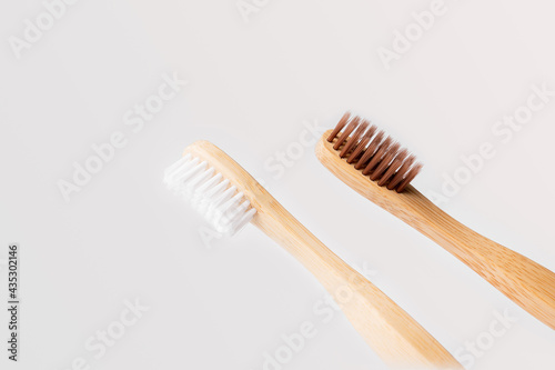 two wooden toothbrushes on light background