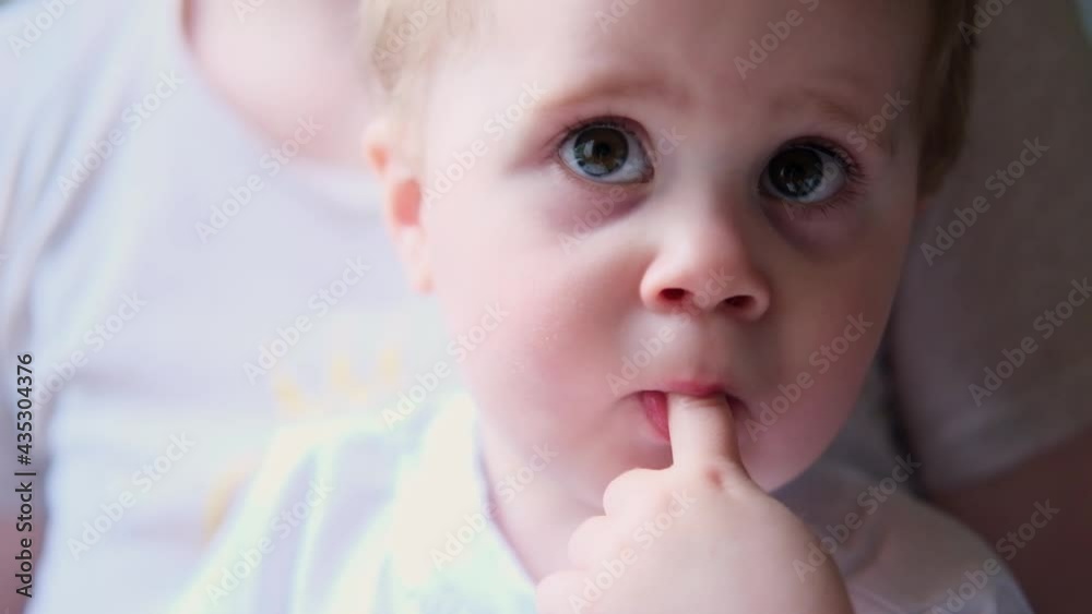 4K cute little baby boy sucking thumb sitting in mom's hands 4K cute little baby boy sucking thumb sitting in mom's hands
