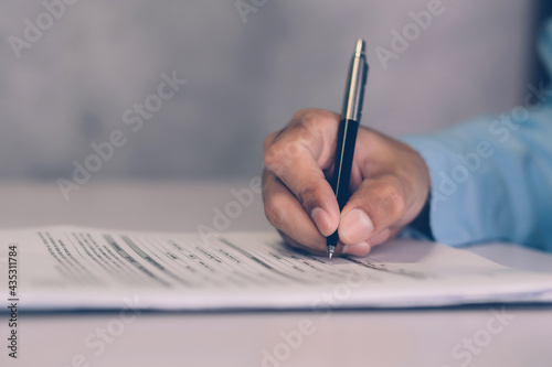 Hands of businessman signing contract about agreement for success on desk in the office, man signature document paperwork with pen, legal insurance and decision for deal, business concept.