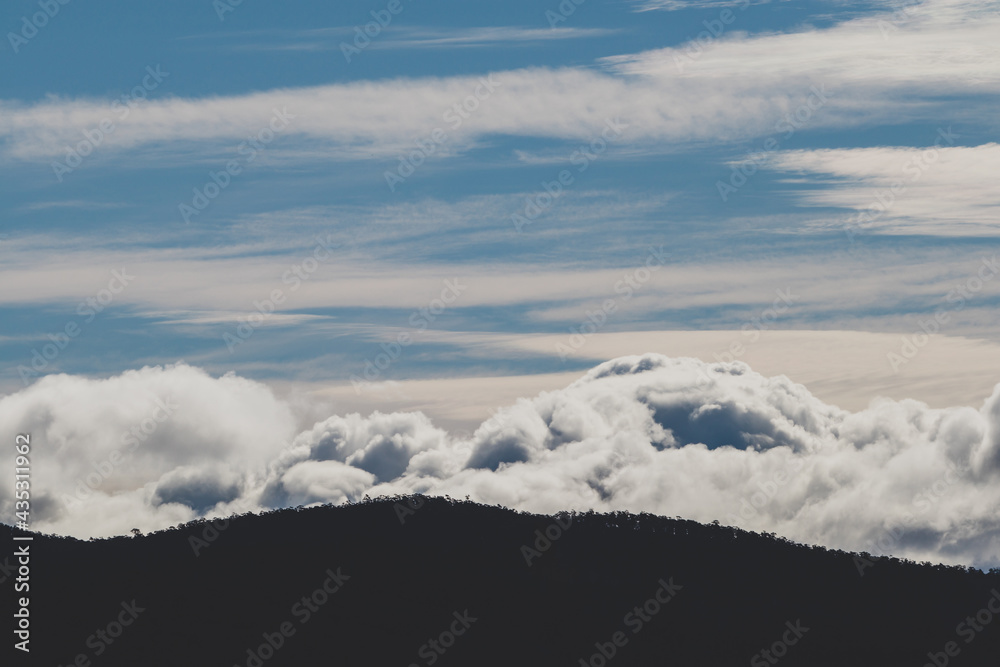 beautiful sky with clouds rolling over the mountains in Tasmania, Australia beautiful sky with clouds rolling over the mountains in Tasmania, Australia