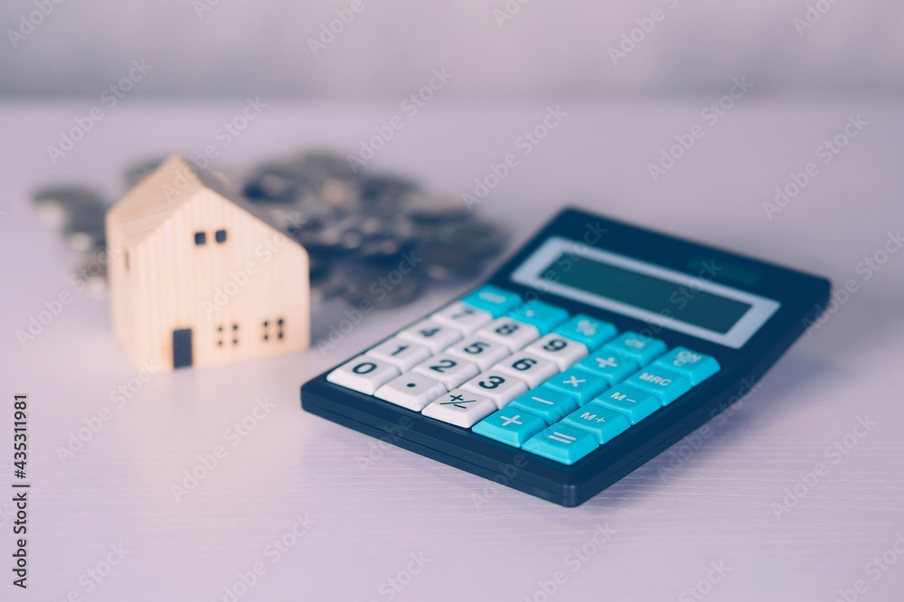 Investment about home with calculator and model house and coins on desk, property and real estate and mortgage, loan and finance, financial saving and account for residential, business concept. Investment about home with calculator and model house and coins on desk, property and real estate and mortgage, loan and finance, financial saving and account for residential, business concept.