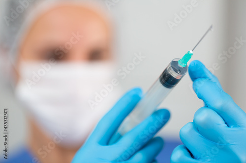Nurse with vaccine. Nurse are showing syringe of coronavirus vaccine