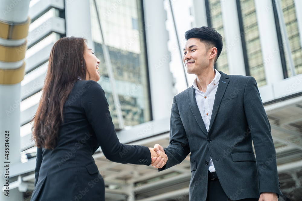 Asian business people greeting by making handshake outdoor in the city Asian business people greeting by making handshake outdoor in the city