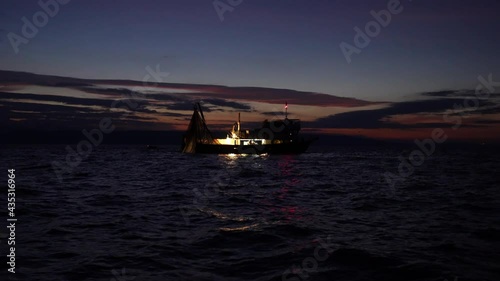 Fisherman On A Lighted Boat Fishing At The Adriatic Sea During Daybreak. - Static Shot