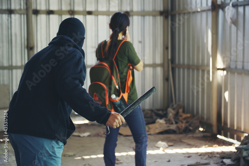 Obraz na płótnie Thief armed man rob woman by baton on street stalker behind young woman back