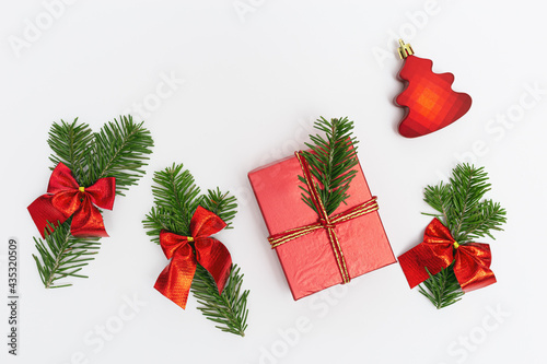 Christmas background with decorated green tree fir branches and red gift box on white © yrabota
