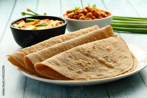 Homemade delicious whole wheat chapati served with chickpeas ,masala curry, Indian  traditional foods background, photo