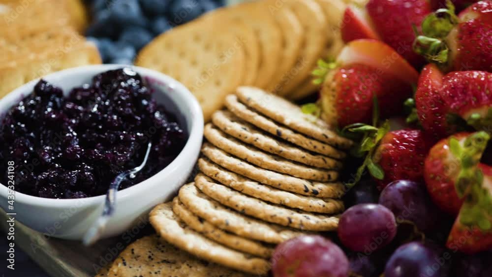 Arranging gourmet cheese, crakers, and fruits on a board for a large cheese board. Arranging gourmet cheese, crakers, and fruits on a board for a large cheese board.