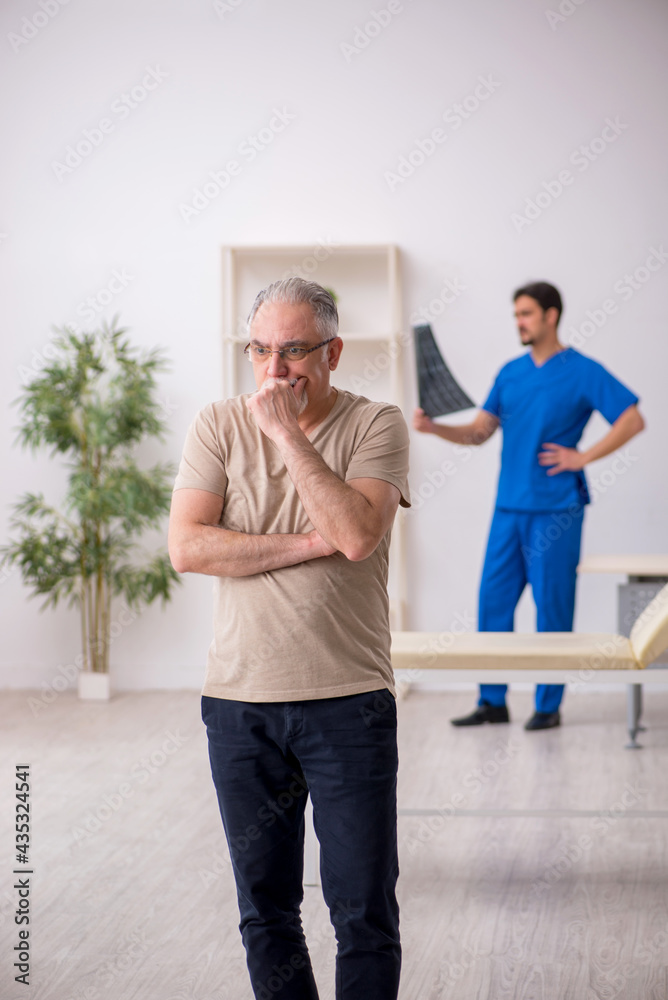 Obraz premium Old male patient visting young male doctor radilogist