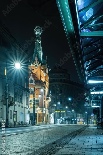 Ulica Basztowa w Krakowie z domem pod globusem w nocy - widoczne tramwaje