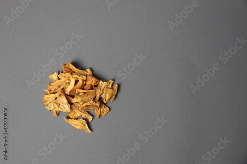 Healthy eating concept - pile of dried pineapple isolated on gray background flat lay
