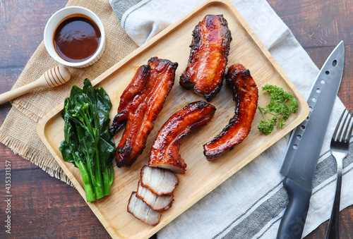 Honey barbecue roast pork on wood tray of wood table - Chinese style grilled pork called Char Siu pork
