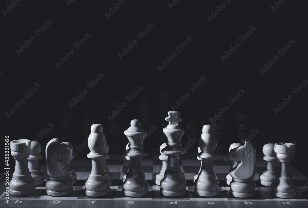 Game board with chess pieces on dark background Game board with chess pieces on dark background