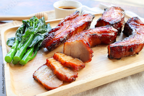 Char Siu - Honey barbecue roast pork on wood tray of wood table - Chinese style grilled pork at close up view