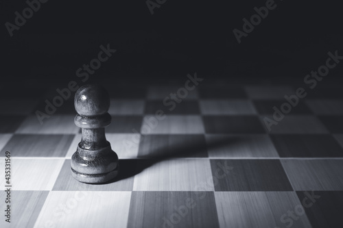 Chess board with pawn on dark background