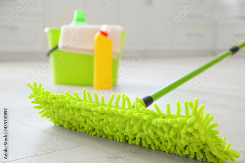 Set of cleaning supplies on floor in kitchen  closeup