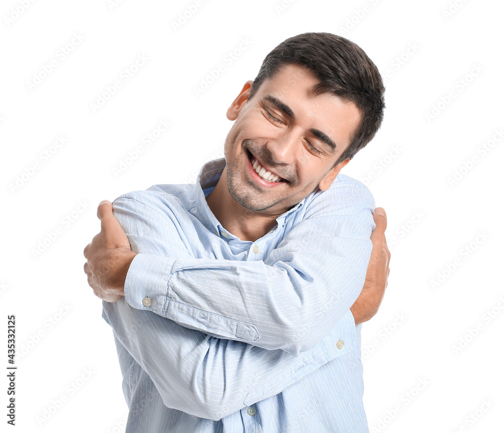 Young man hugging himself on white background Young man hugging himself on white background