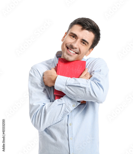 Young man hugging books on ...