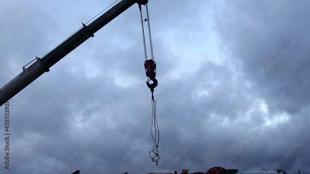 The silhouette of a working truck crane and a special vehicle for servicing oil wells dismantles equipment against the background of the evening sky The silhouette of a working truck crane and a special vehicle for servicing oil wells dismantles equipment against the background of the evening sky