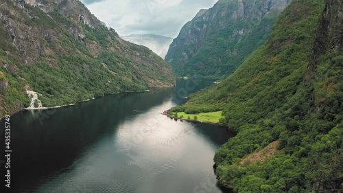 A magnificent view of the Naeroyfjord. UNESCO heritage site and one of the most beautiful fjords in Norway. Forest-covered mountains tower above the narrow waterway. Ripples run on the water surface. photo