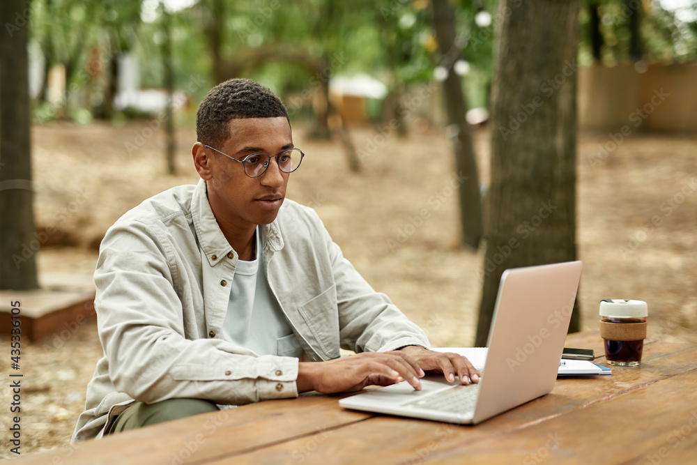 Young african american man freelancer typing on laptop Young african american man freelancer typing on laptop